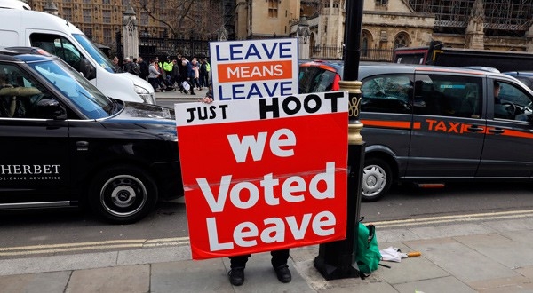 Un manifestante a favor del Brexit muestra una pancarta en la que se puede leer "Votamos salir" en las afueras del parlamento británico en Westminster.