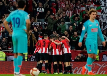 Jugadores del Bilbao celebran ante la decepción del Atlético.