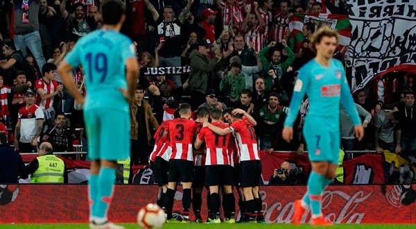 Jugadores del Bilbao celebran ante la decepción del Atlético.