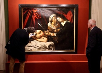 Visitantes observan una pintura titulada "Judith y Holofernes" durante su presentación en París, Francia.