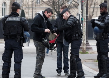 Gendarmes franceses registran a viandantes en la avenida de los Campos Elíseos antes de la nueva protesta de los en París, Francia, el 23 de marzo de 2019