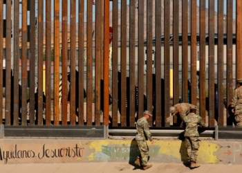 Soldados estadounidenses caminan junto a la cerca fronteriza entre México y Estados Unidos en El Paso, Texas.