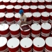 Un trabajador etiqueta barriles de lubricante de petróleo.