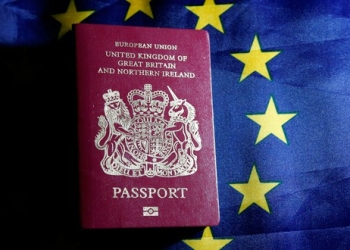 Un pasaporte británico frente a una bandera de la Unión Europea.