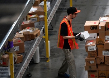 Empleado moviendo paquetes en un centro de almacenamiento de Amazon en Baltimore, Maryland.