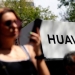 Transeúntes caminando frente a un logo de Huawei en Ciudad de México.