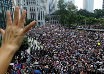 Manifestantes en Hong Kong alzaron la bandera de EEUU y sus manos para pedir ayuda internacional