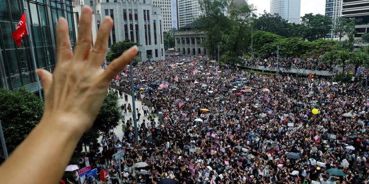 Manifestantes en Hong Kong alzaron la bandera de EEUU y sus manos para pedir ayuda internacional