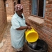 Una mujer vierte el agua recolectada de un camión cisterna municipal en un contenedor de almacenamiento en un municipio en Graaff-Reinet, Sudáfrica. Foto tomada el 17 de noviembre de 2019 por Mike Hutchings