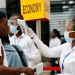 Una trabajadora de la salud chequea la temperatura de un viajero en el aeropuerto internacional de Kotoka en Accra, Ghana, como parte de las medidas para evitar la propagación del coronavirus