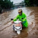 Un hombre camina con su scooter en una carretera inundada, tras fuertes lluvias en Yakarta (Indonesia), el 1 de enero de 2020. Antara Foto / Aprillio Akbar