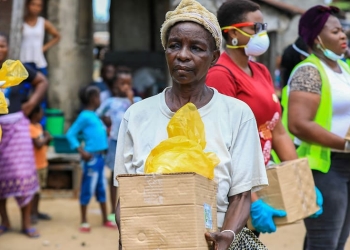 Una mujer mayor recibe en Lagos (Nigeria) comida por parte de organizaciones voluntarias