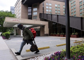 A member of the homeless community walks past a Hyatt hotel that is completely closed to guests during the coronavirus disease (COVID-19) outbreak, in Washington, U.S. May 8, 2020. New unemployment data shows the U.S. economy lost a staggering 20.5 million jobs in April. REUTERS/Jonathan Ernst