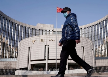 Un hombre con una máscara pasa por la sede del Banco Popular de China, el banco central, en Beijing, China, cuando el país se ve afectado por un brote del nuevo coronavirus, el 3 de febrero de 2020. REUTERS / Jason Lee