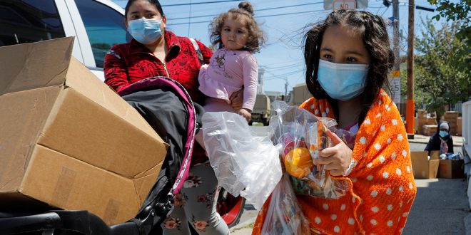 Una familia se lleva víveres gratis de una despensa emergente en medio del brote de la enfermedad del coronavirus (COVID-19) en Chelsea, Massachusetts, EE. UU., 19 de mayo de 2020. REUTERS / Brian Snyder