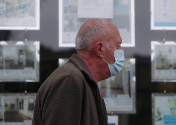 Un hombre con una máscara protectora pasa frente a una agencia inmobiliaria durante el brote de la enfermedad del coronavirus (COVID-19) en Madrid, España, 24 de abril de 2020. Fotografía tomada el 24 de abril de 2020. REUTERS / Susana Vera / File Photo