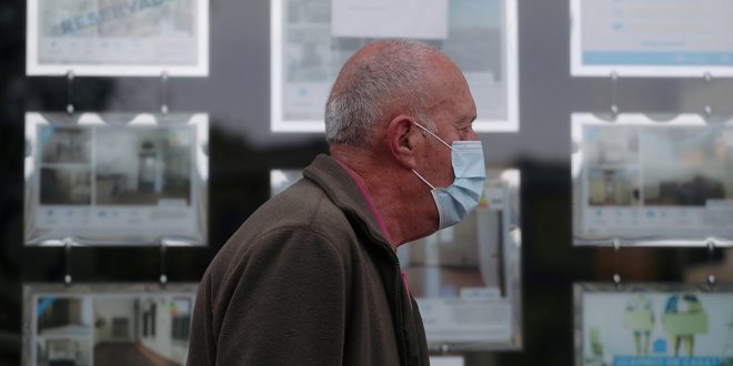 Un hombre con una máscara protectora pasa frente a una agencia inmobiliaria durante el brote de la enfermedad del coronavirus (COVID-19) en Madrid, España, 24 de abril de 2020. Fotografía tomada el 24 de abril de 2020. REUTERS / Susana Vera / File Photo