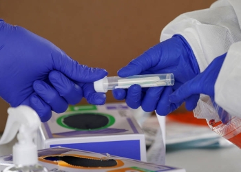 Trabajadores procesan una prueba en un sitio de tránsito para recolectar muestras para la pandemia de la enfermedad por coronavirus (COVID-19) en Leesburg, Virginia, EE. UU., 20 de mayo de 2020. REUTERS / Kevin Lamarque