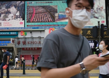 La gente pasa frente a una pantalla de televisión que muestra noticias sobre la aprobación de la ley de Seguridad Nacional de Hong Kong en Beijing, en Hong Kong, China, 28 de mayo de 2020. REUTERS / Tyrone Siu