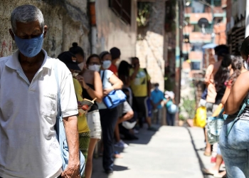 La gente hace una fila para recibir alimentos de una organización benéfica, en el barrio de Carapita, durante la cuarentena nacional debido al brote de la enfermedad por coronavirus (COVID-19), en Caracas, Venezuela, 30 de abril de 2020. Fotografía tomada el 30 de abril de 2020. REUTERS / Manaure Quintero