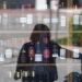 Una mujer se refleja en el escaparate de una tienda mientras espera entrar, durante el brote de la enfermedad por coronavirus (COVID-19), en Ronda, sur de España, el 3 de abril de 2020. REUTERS / Jon Nazca