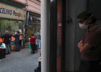 Un hombre que lleva una máscara facial protectora mantiene la distancia social mientras espera comprar en un puesto de frutas, en medio del brote de la enfermedad del coronavirus (COVID-19), en Madrid, España, 5 de mayo de 2020. REUTERS / Susana Vera