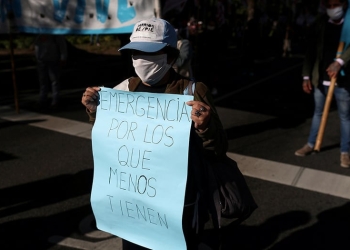 Un manifestante con una máscara facial sostiene un cartel que dice "emergencia para los que menos tienen", durante una protesta para exigir recursos para los vulnerables, en medio de la enfermedad por coronavirus (COVID-19), en Buenos Aires, Argentina, el 11 de junio de 2020. REUTERS / Agustin Marcarian / Foto de archivo