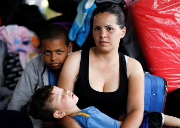 La inmigrante venezolana Erika Fernández, de 33 años, posa para una foto con sus hijos Ronald, de 10 años, y José, de 3, mientras esperan para procesar sus documentos en el centro de servicio fronterizo ecuatoriano-peruano, antes de continuar su viaje, en las afueras de Tumbes, Perú, 16 de junio de 2019. Fernández, una enfermera, viaja para encontrarse con su esposo que ha estado en Perú durante un año.