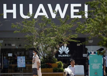 La gente pasa frente a una tienda Huawei en un complejo comercial en Beijing, China, 14 de julio de 2020. REUTERS / Tingshu Wang