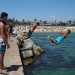 Hombres se lanzan al agua mientras que disfrutan del sol en la playa después de que se anunciaron limitaciones para contener la propagación de la enfermedad por el nuevo coronavirus COVID-19 en Barcelona, España. 19 de julio de 2020. REUTERS/Nacho Doce