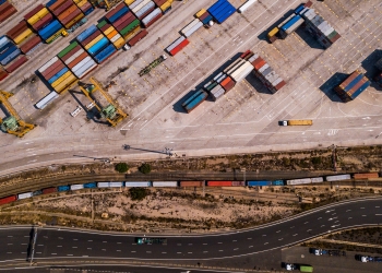 Área de carga industrial con buque portacontenedores, vista aérea del muelle de transporte. Valencia, España.